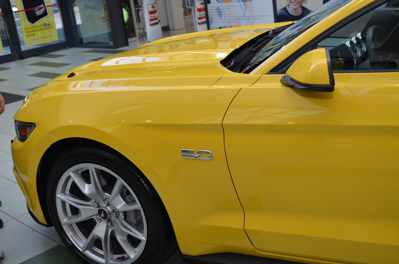 Yellow muscle car front fender with 5.0 badge and alloy wheel