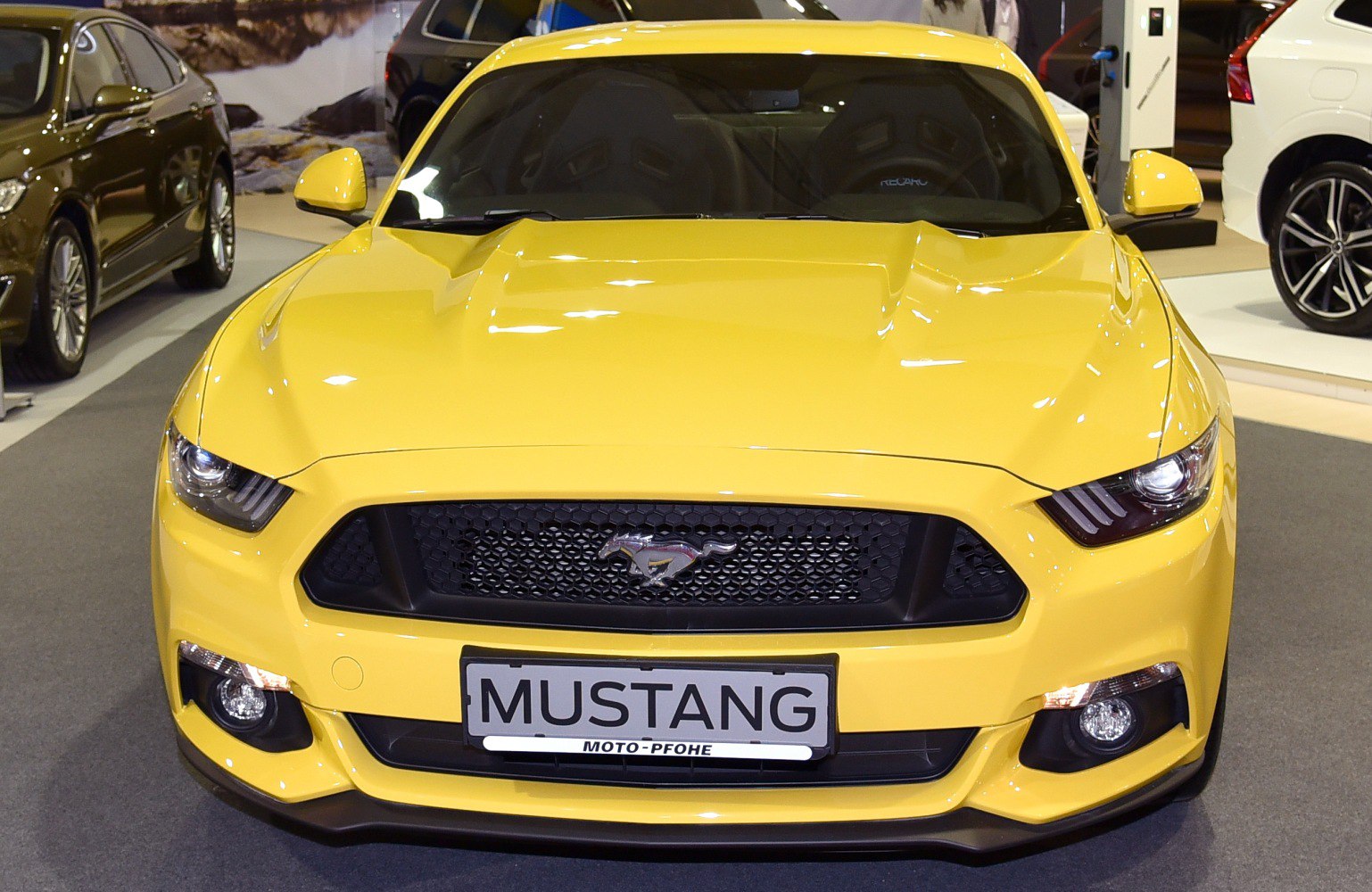 Yellow car front with aggressive grille and sharp headlights