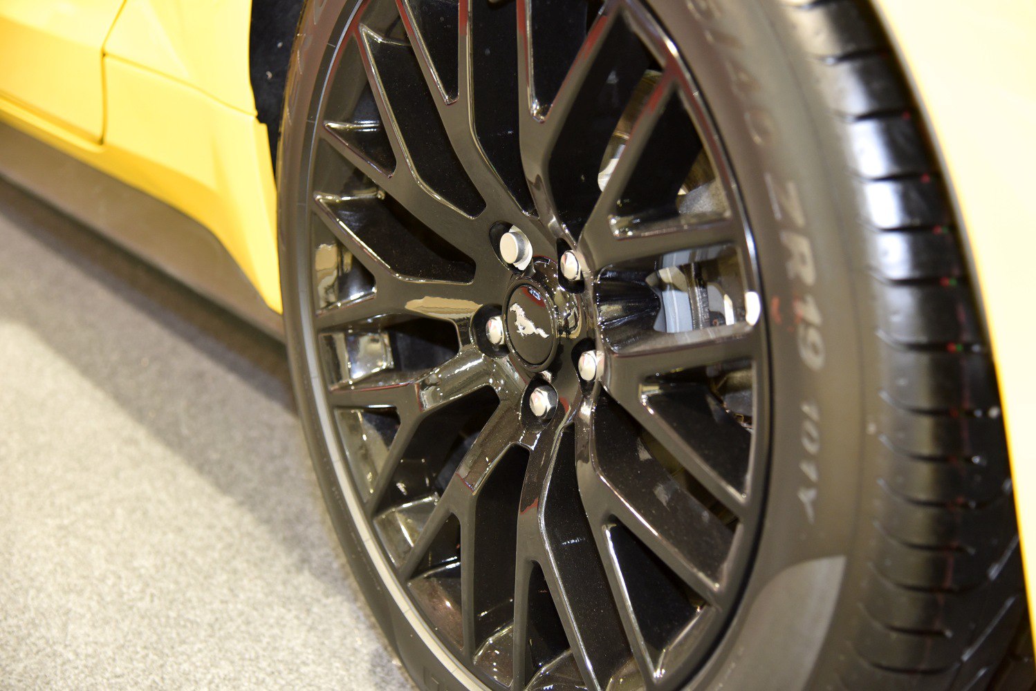 Close-up of black multi-spoke alloy wheel and performance tire.