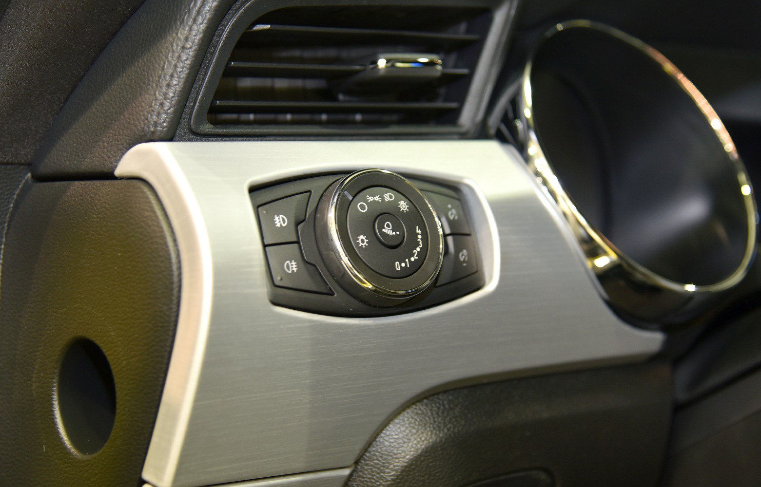 Headlight control switch and air vent with brushed metal dashboard trim