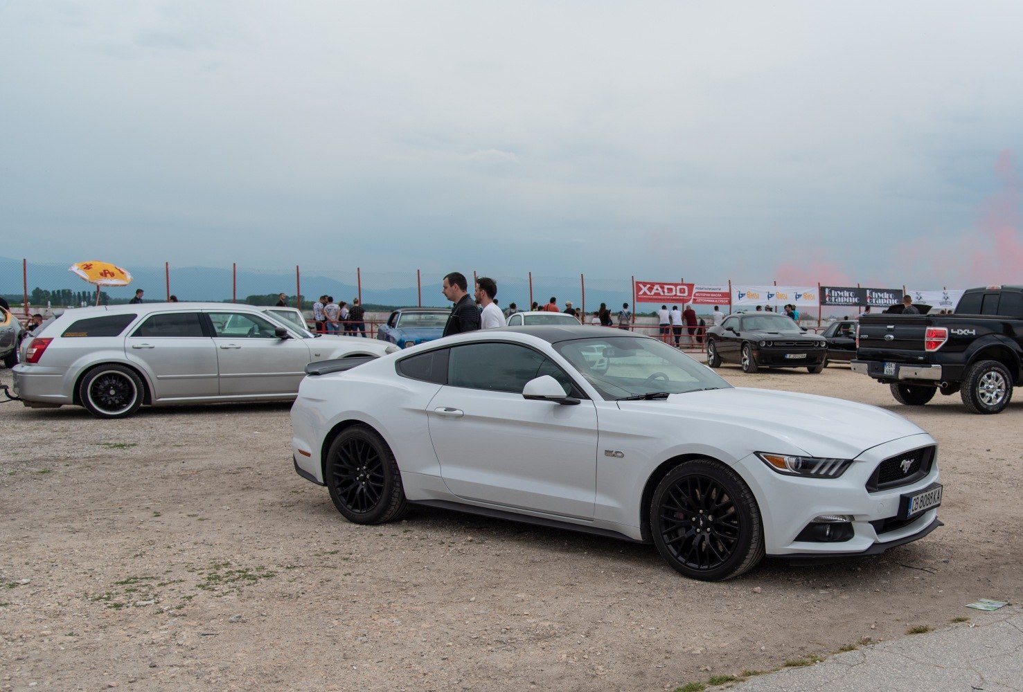 White sports coupe with black wheels parked outdoors