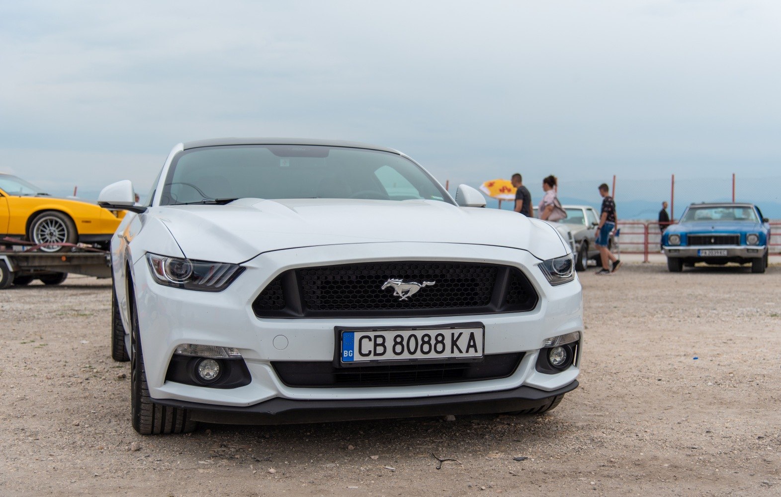 Front view of a white vehicle showing a distinctive grille and angular headlights