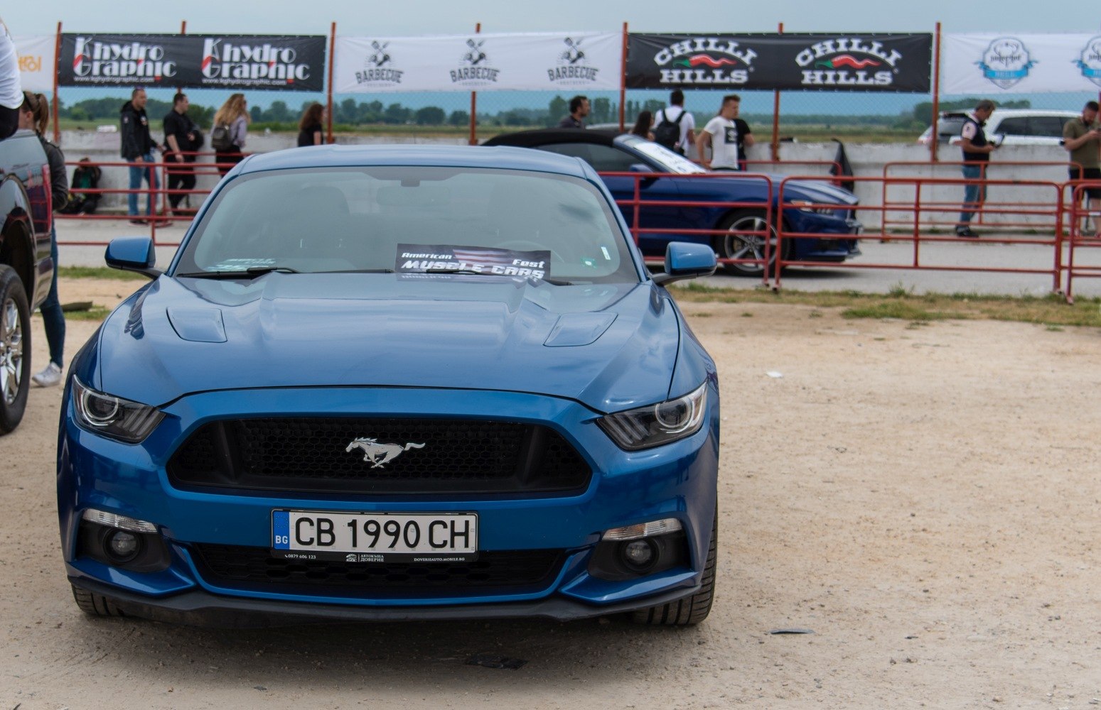 Muscle car front with aggressive headlights and hood scoops
