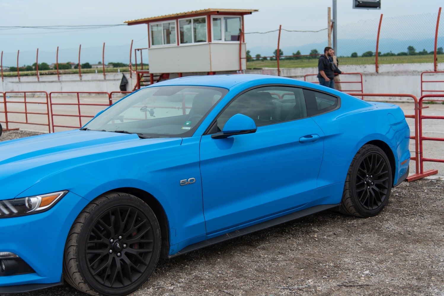 Blue sporty coupe with 5.0 V8 badge and black alloy wheels