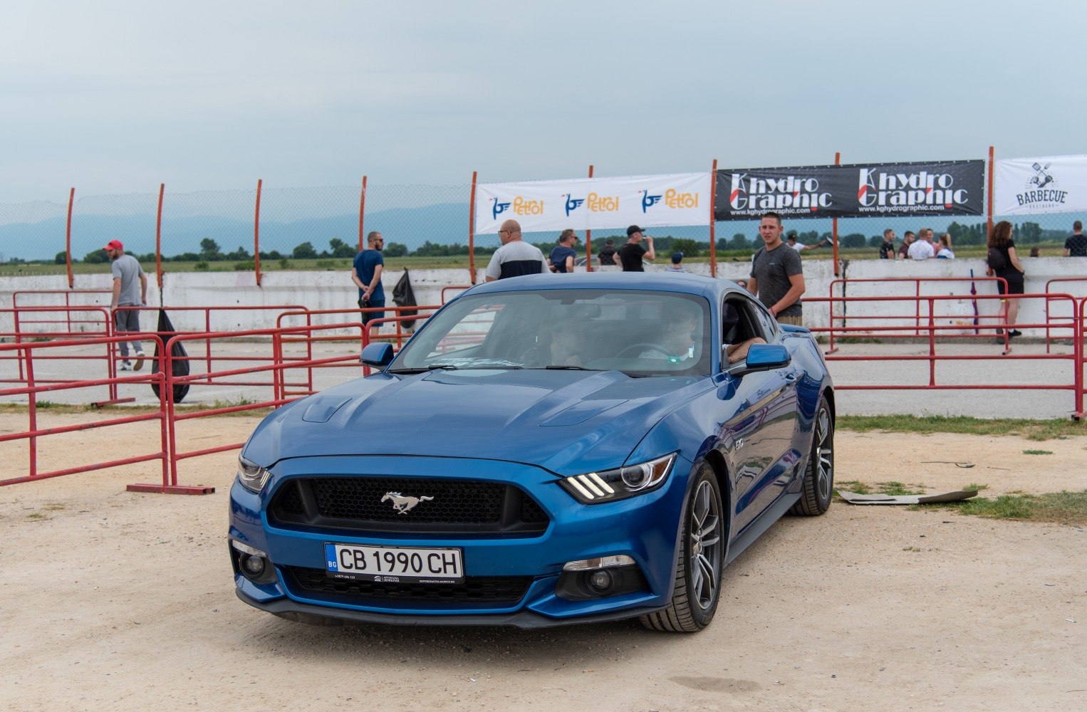 Blue muscle car front view with LED headlights and sporty wheels