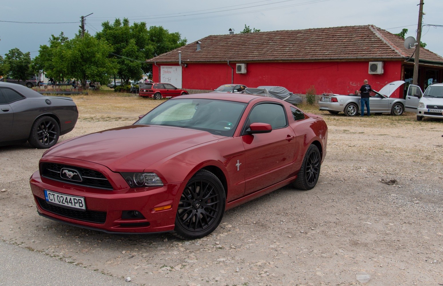 Red fastback coupe with black wheels and aggressive front grille