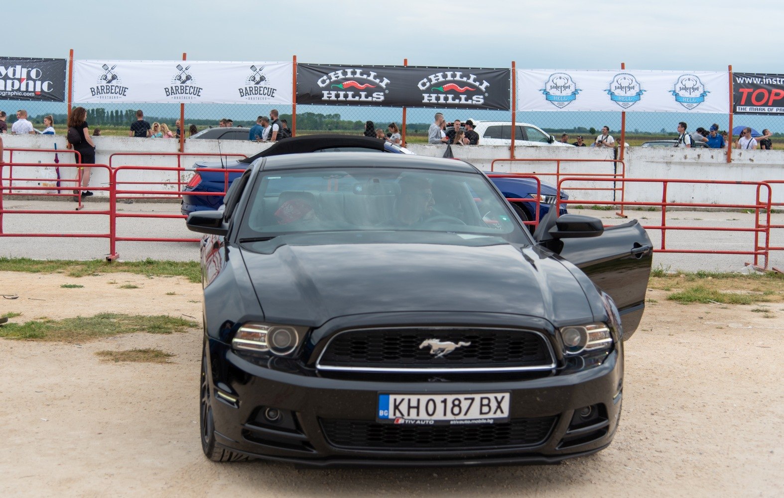 Front view of a black Mustang with prominent grill and headlights