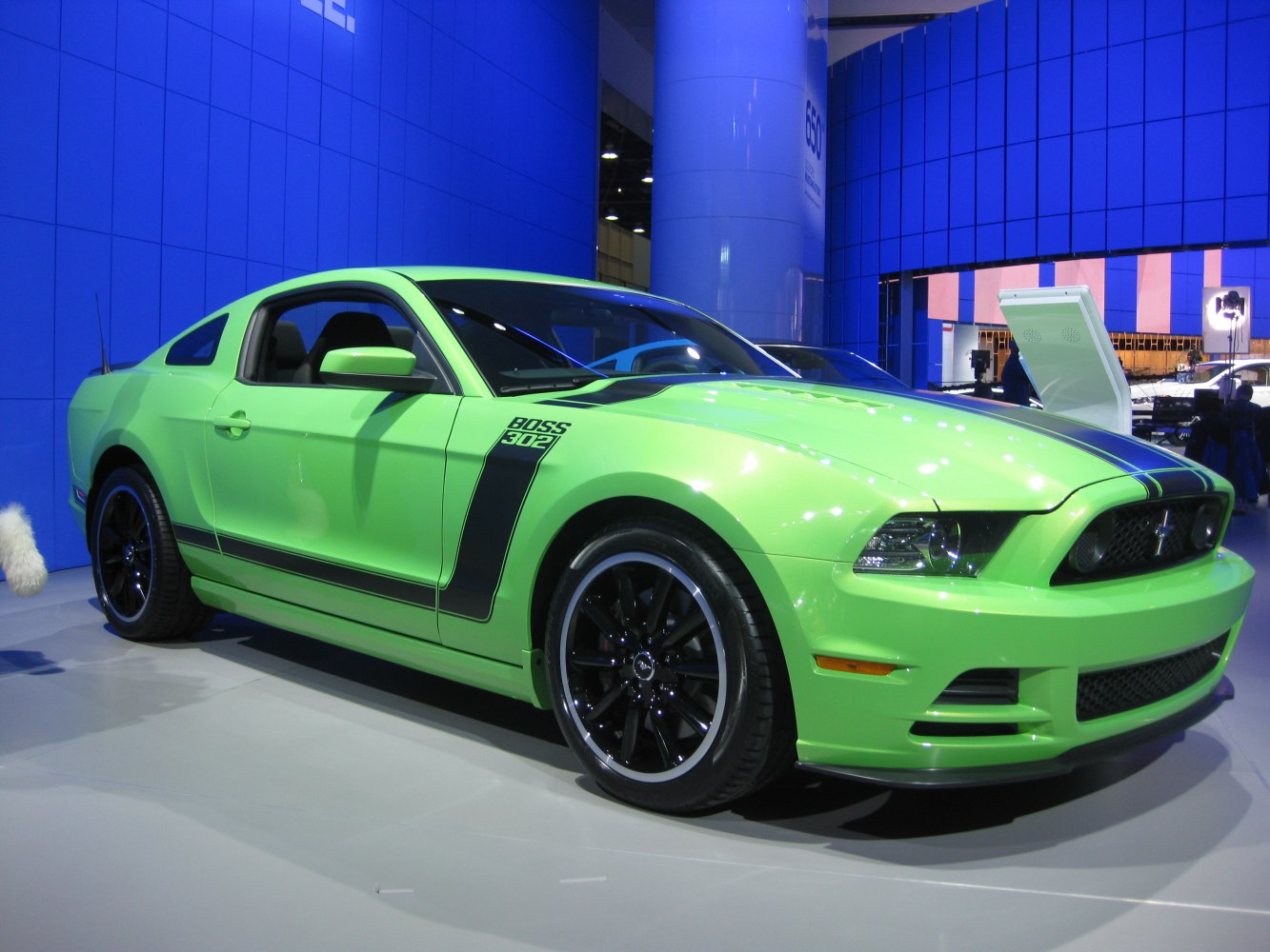 Green muscle coupe with black racing stripes and sporty wheels