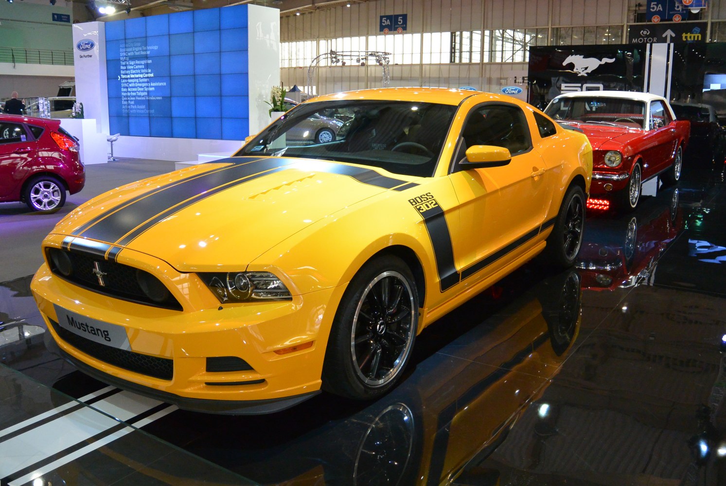 Yellow Mustang V Boss 302 with black racing stripes