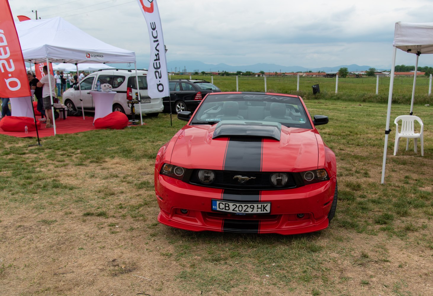 Red convertible with hood scoop and black racing stripes