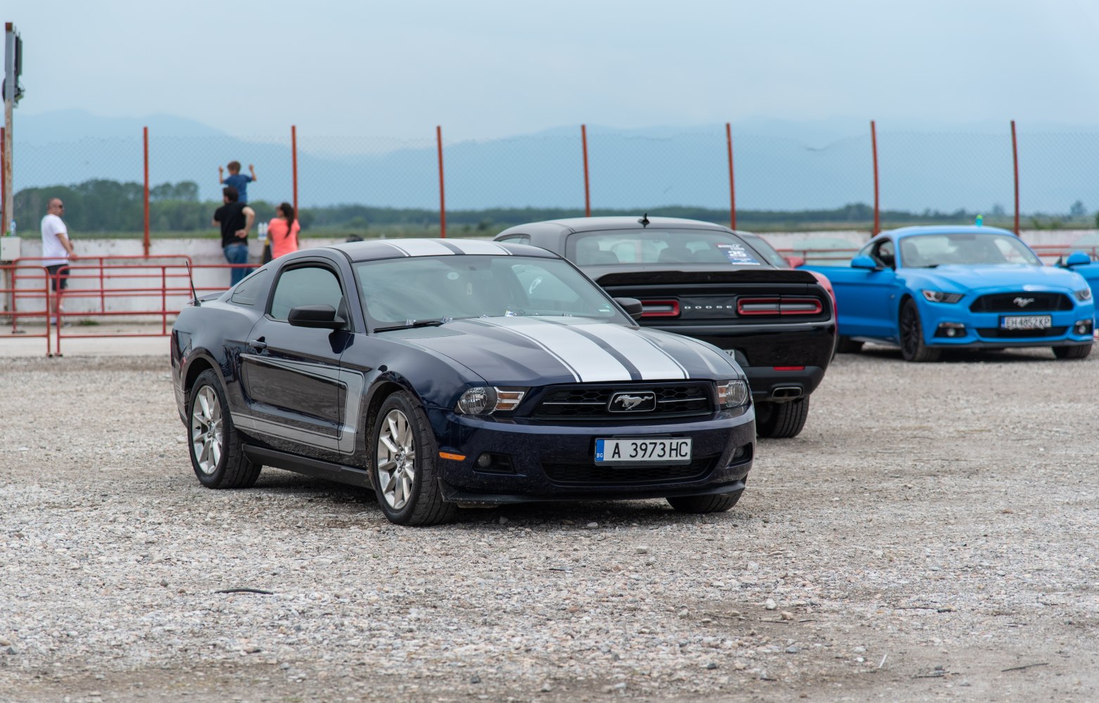 Front view of a sporty coupe with racing stripes and pony emblem grille