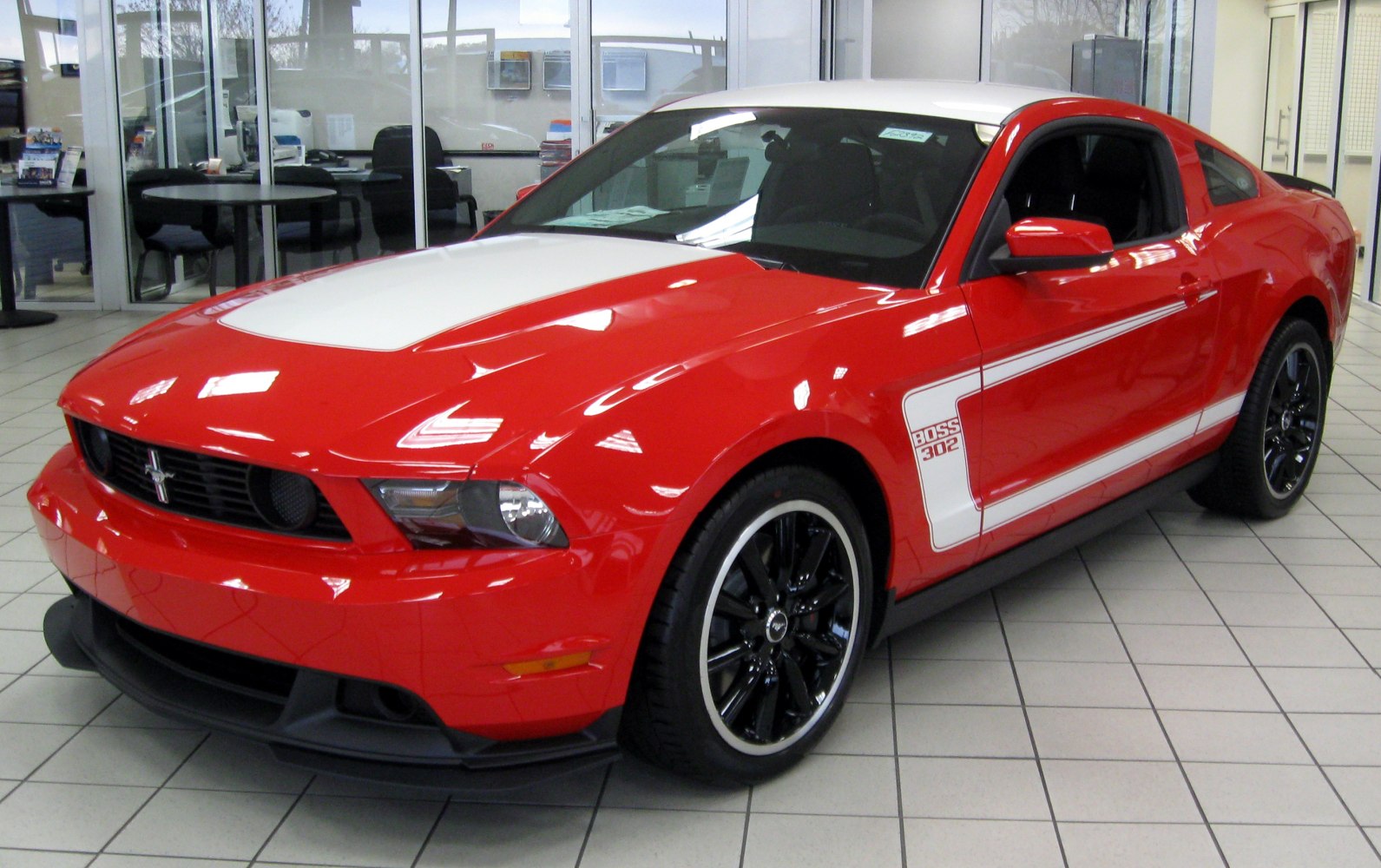 Red sports coupe with white racing stripes, 'Boss 302' decal, and black wheels