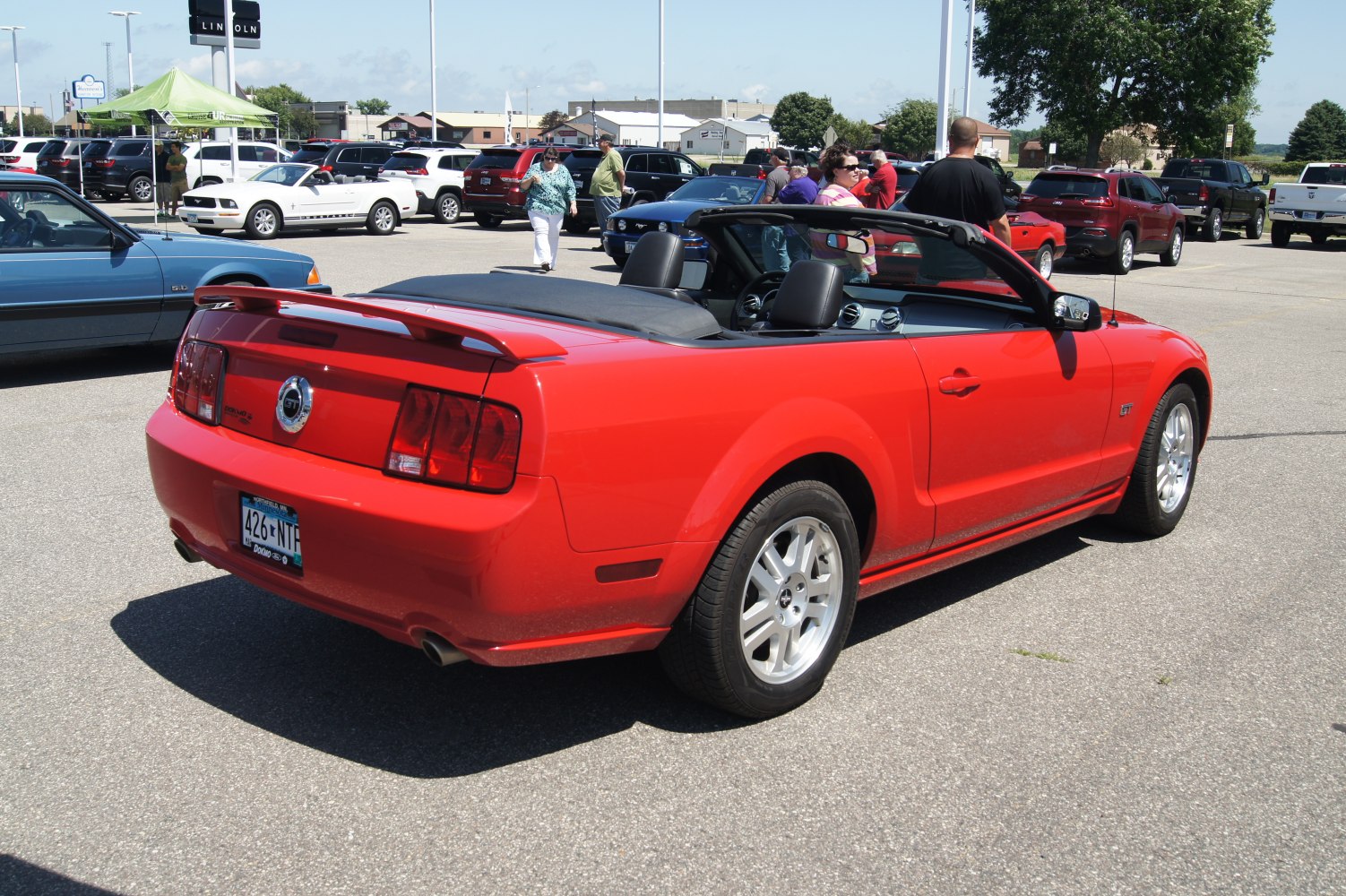 Rear view of a red convertible with spoiler and alloy wheels.