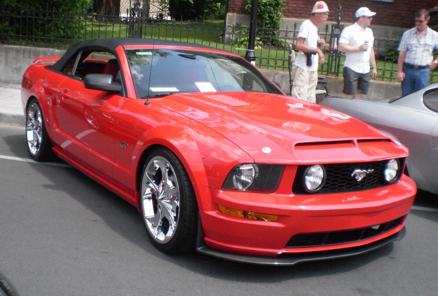 Red convertible with black soft top and custom chrome wheels