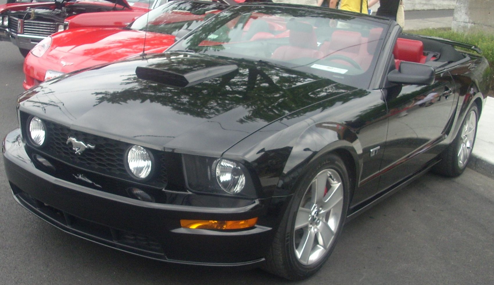 Black convertible with hood scoop, five-spoke wheels, sporty design