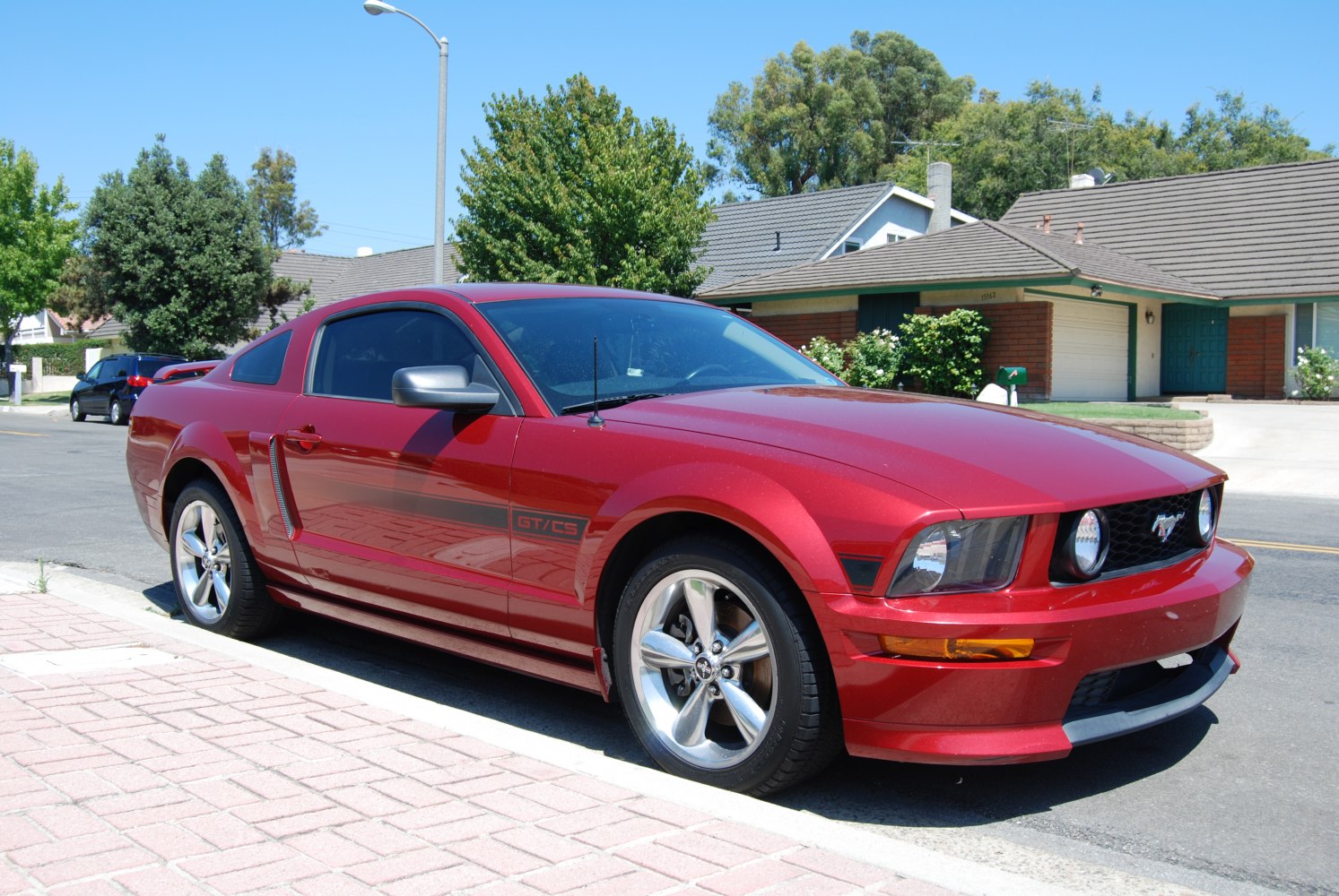 Sporty front angle of a red coupe with alloy wheels