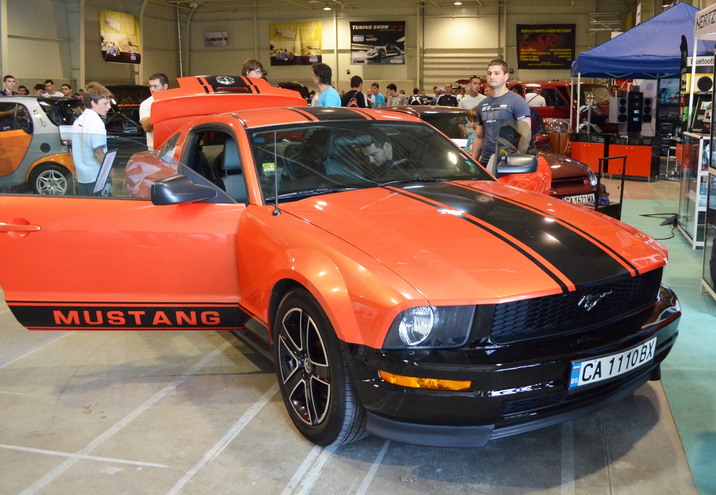 Orange muscle coupe with black racing stripes and custom wheels