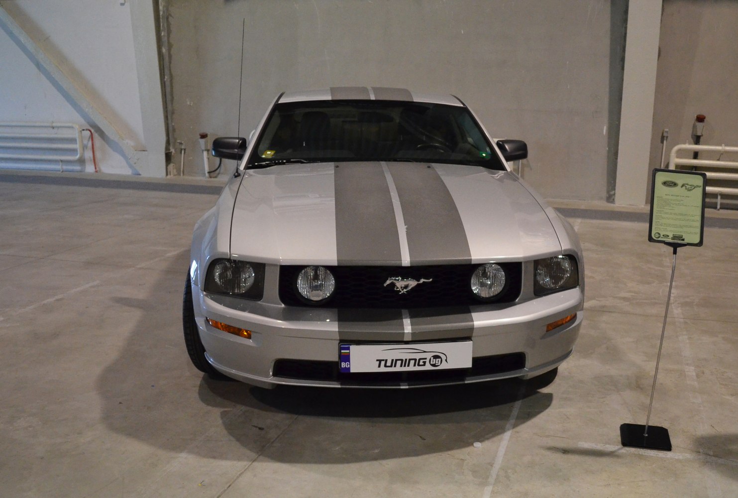 Front view of Mustang with dual racing stripes and round headlights