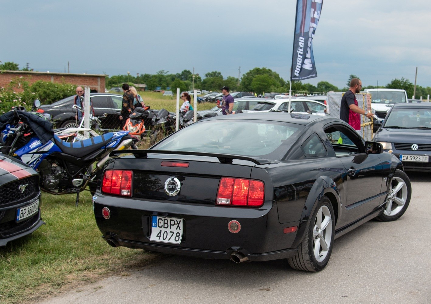 Rear view of a black Mustang with GT badge and dual exhaust.