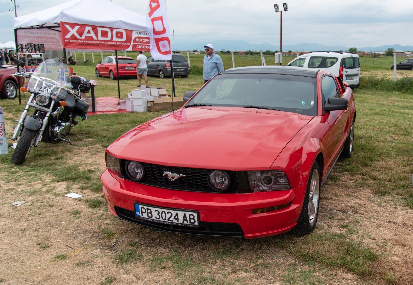 Front view of a red muscle car featuring Mustang grille and headlights