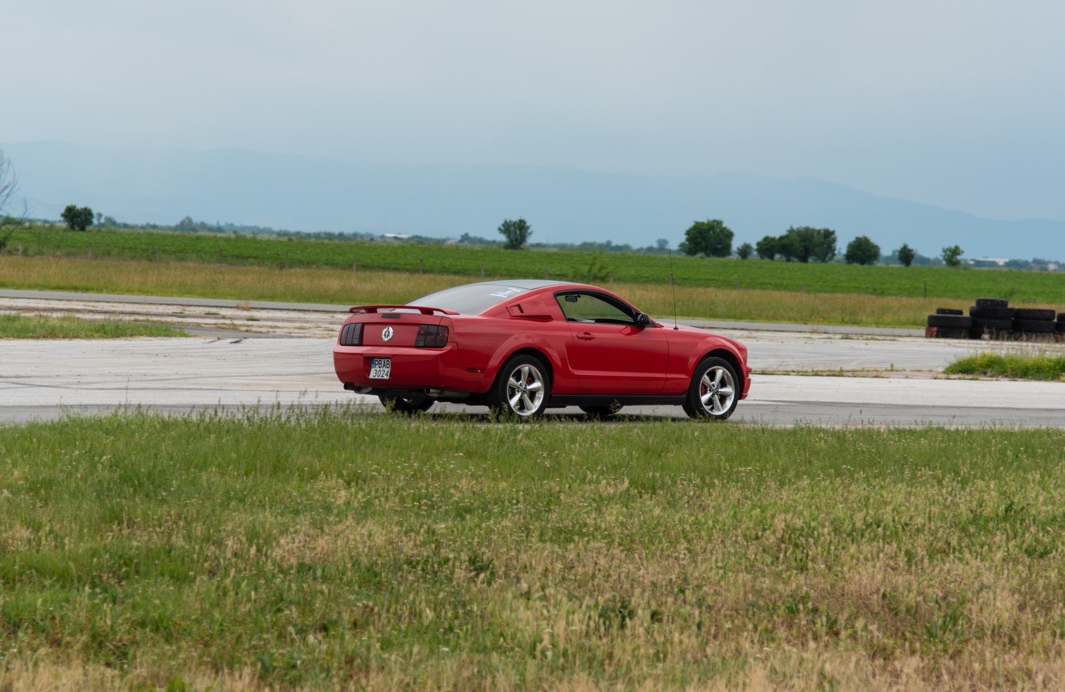 Red sports coupe rear side with spoiler and alloy wheels
