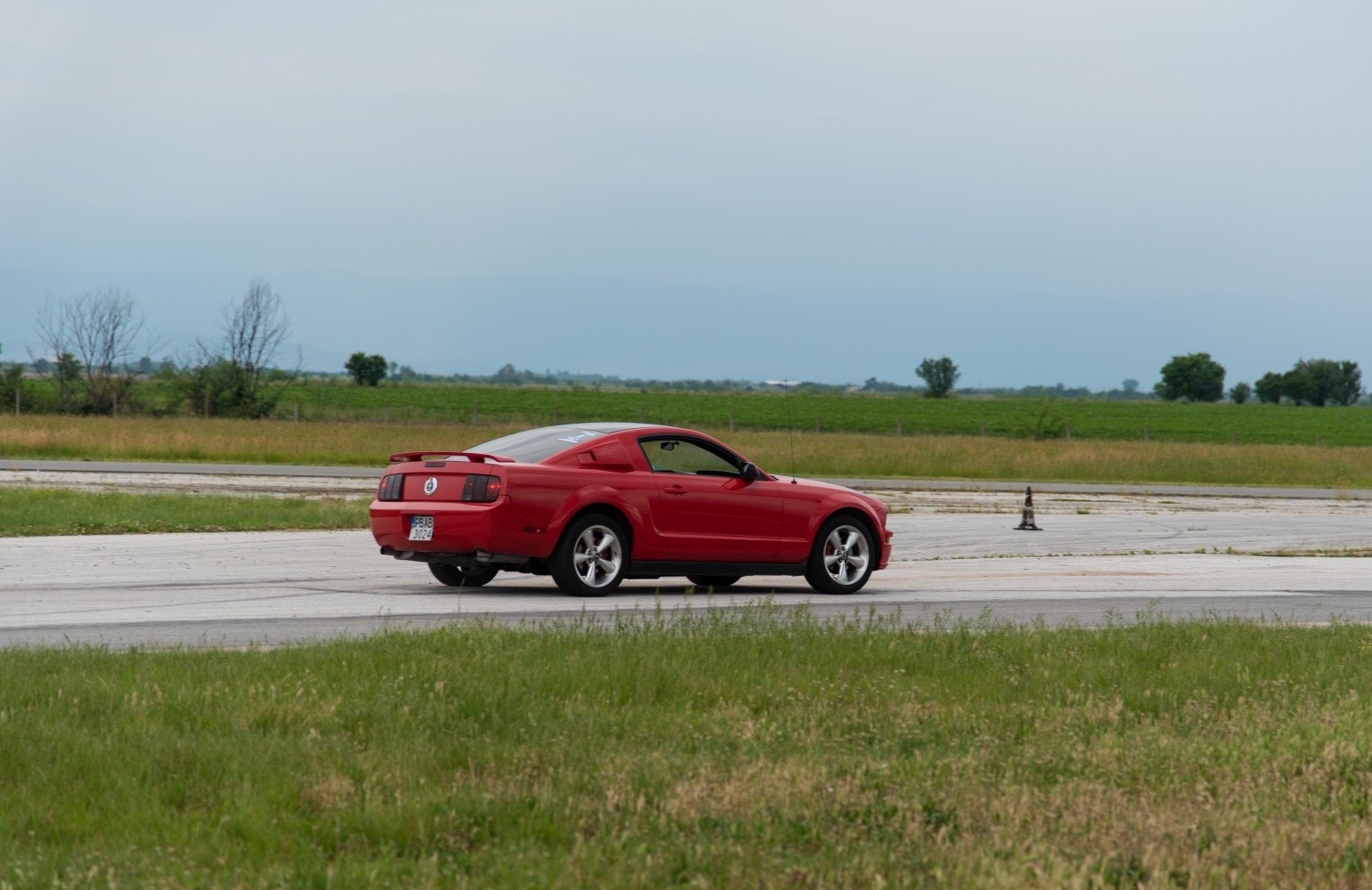 Red Mustang V coupe rear side on race track