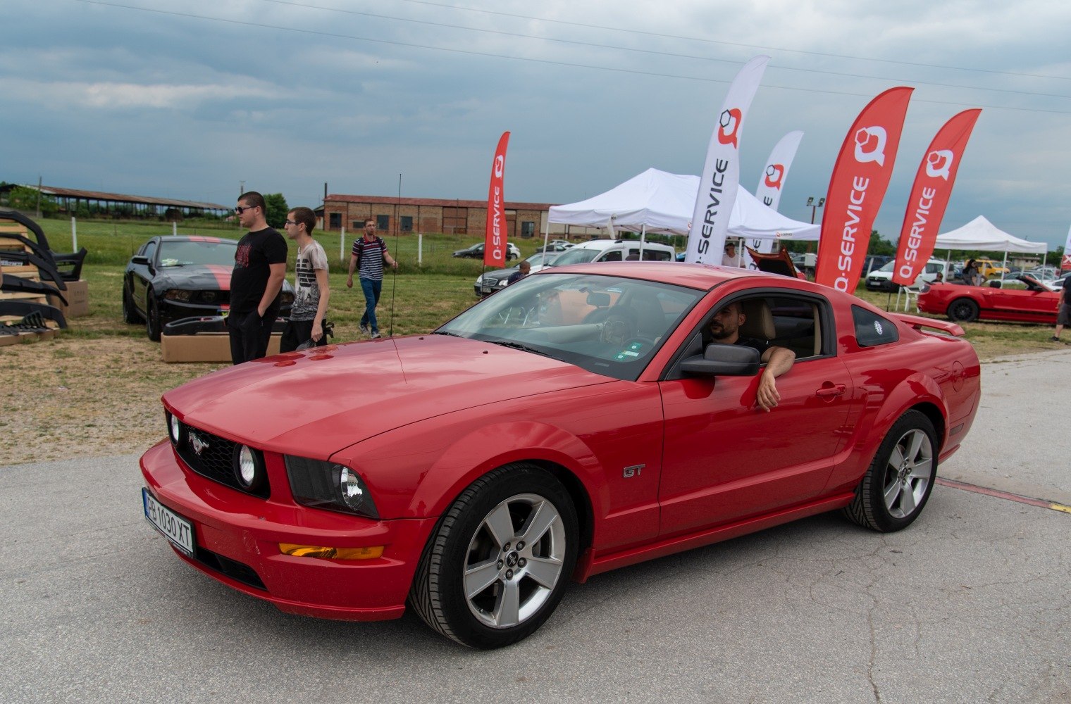 Front side view of red Mustang GT at car event