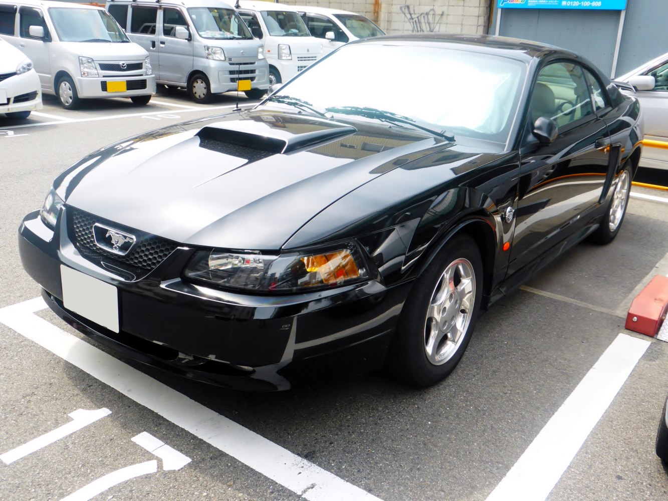 Black coupe with hood scoop and alloy wheels