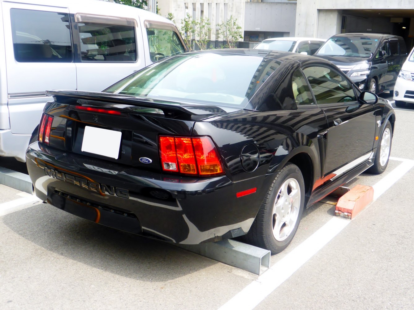 Rear spoiler and taillights of a black sports coupe