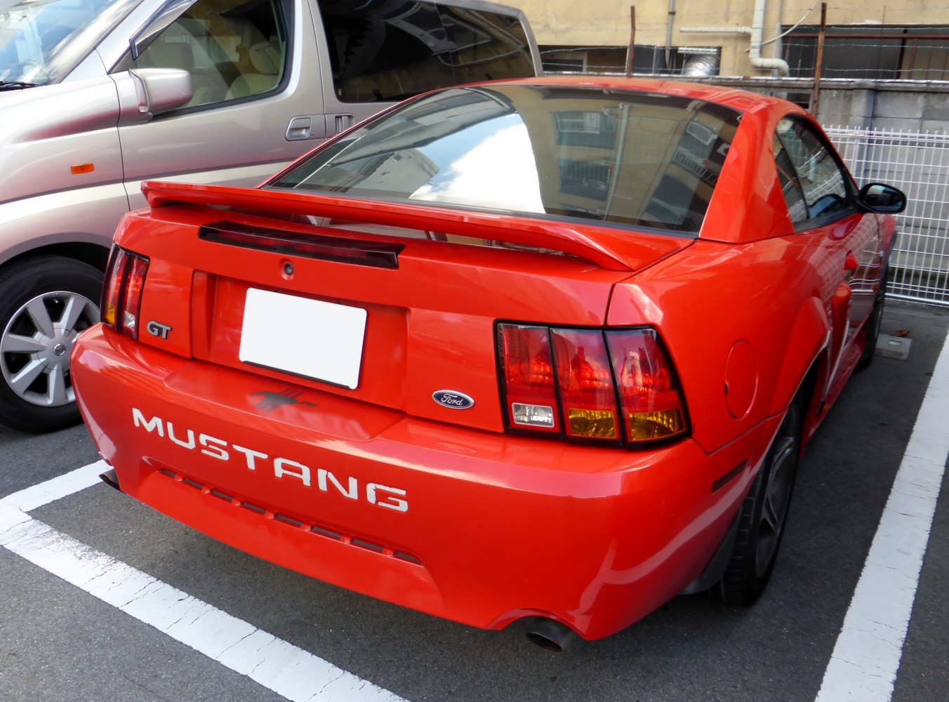 Rear spoiler, GT badge, and distinctive taillights on red sports coupe