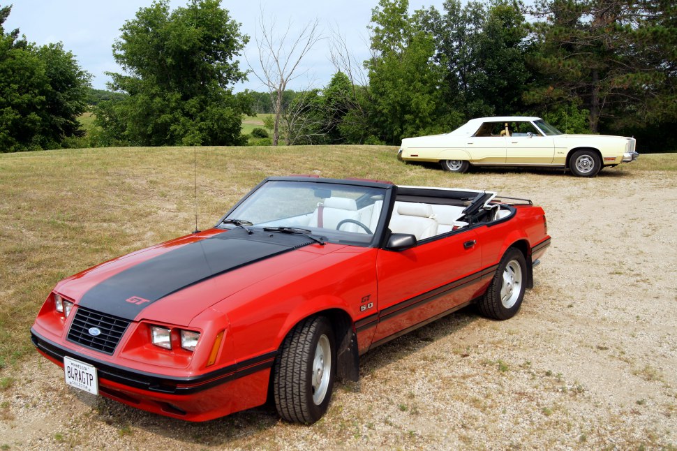 Red Mustang convertible with black hood stripes and white interior