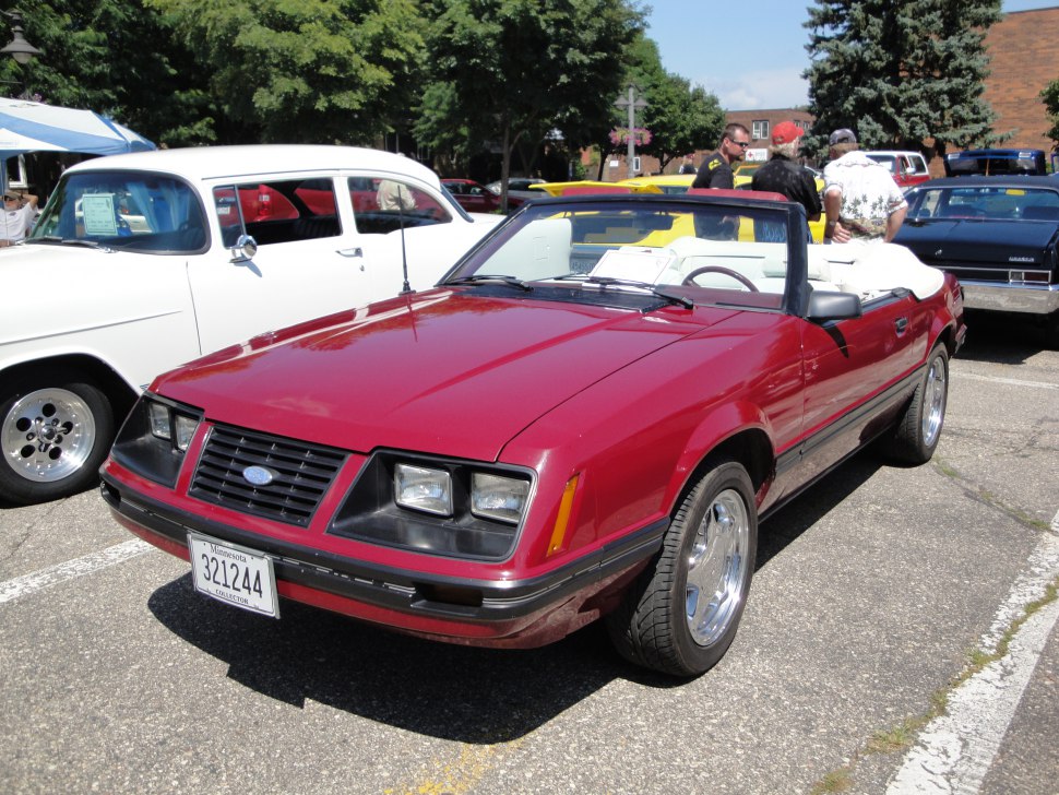 Red convertible with white interior and classic 1980s Ford Mustang styling