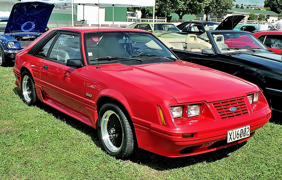Red sporty coupe with quad headlights and aerodynamic side skirts
