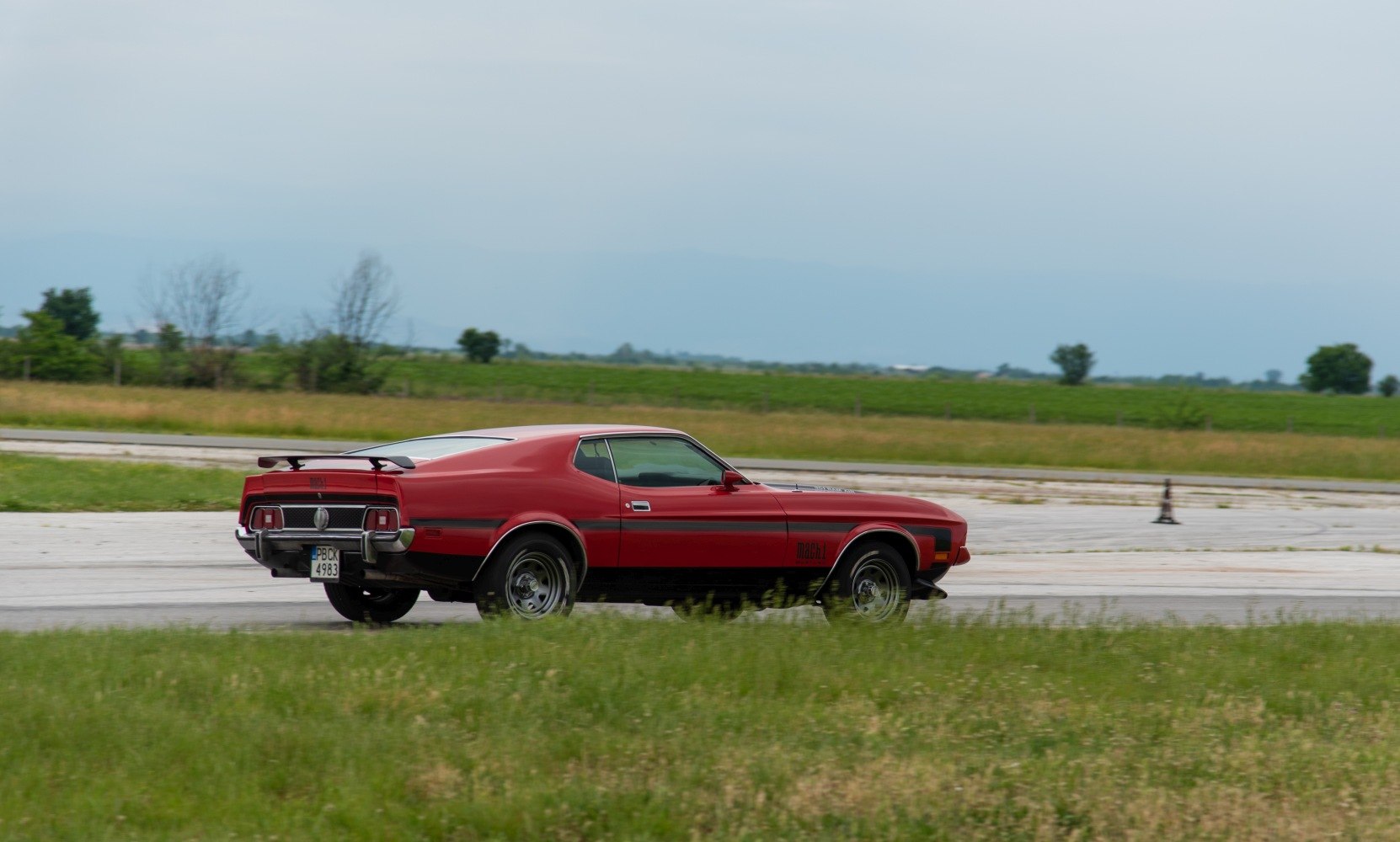 Side and rear view of a classic muscle coupe with rear spoiler
