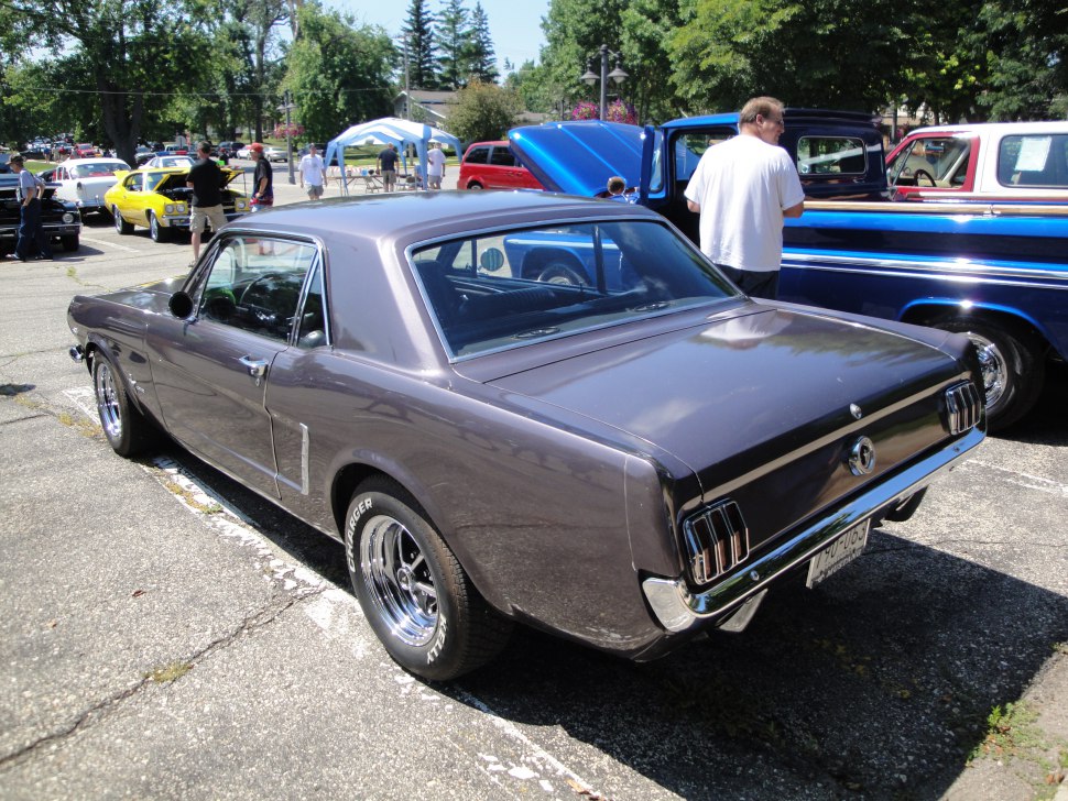 Rear view of a classic two-door coupe with chrome wheels and distinct taillights