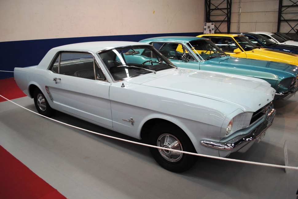 White coupe with chrome front bumper and Mustang emblem