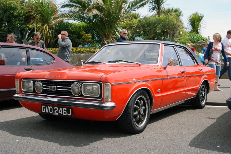 Retro orange classic sedan with dual round headlights and chrome bumper