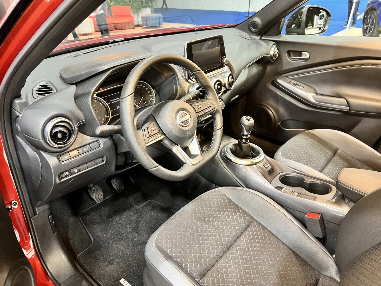 Manual gear shift and modern dashboard with steering wheel and seats