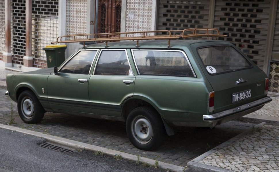 Classic vintage green station wagon with roof rack and steel wheels