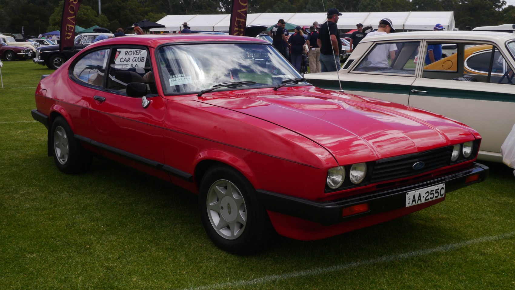 Classic red 1980s coupe with quad headlights and sleek body