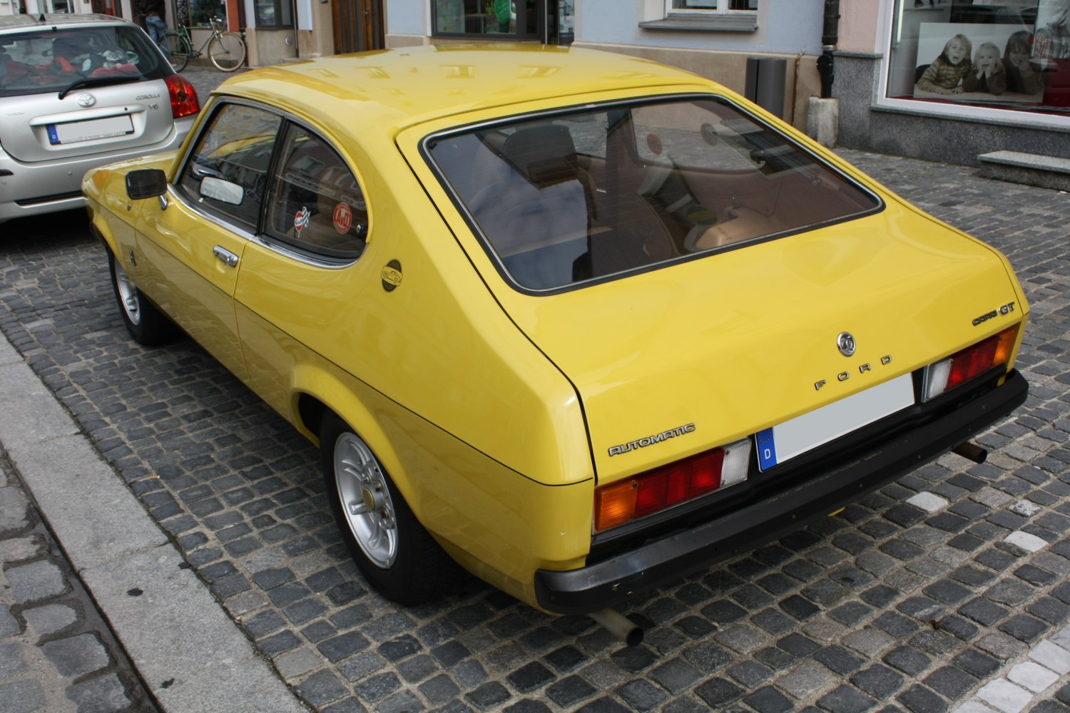 Yellow vintage 1970s coupe rear view with hatchback and automatic badge
