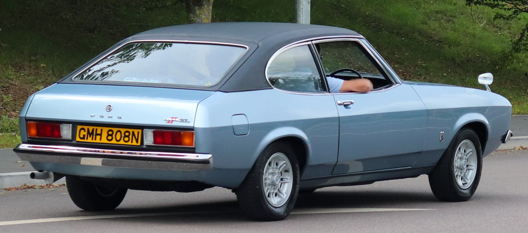 Rear and side view of classic coupe with vinyl roof and alloy wheels