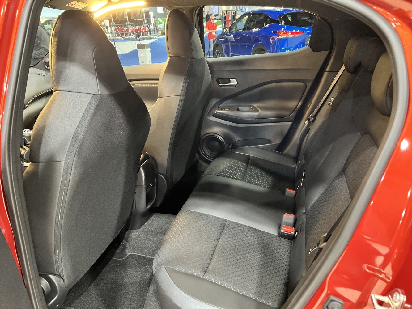 Rear black seats and door panel with textured upholstery in compact car's second row