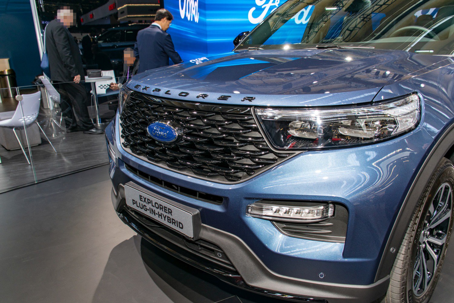 Front grille, headlight, and plug-in hybrid badge of a blue SUV