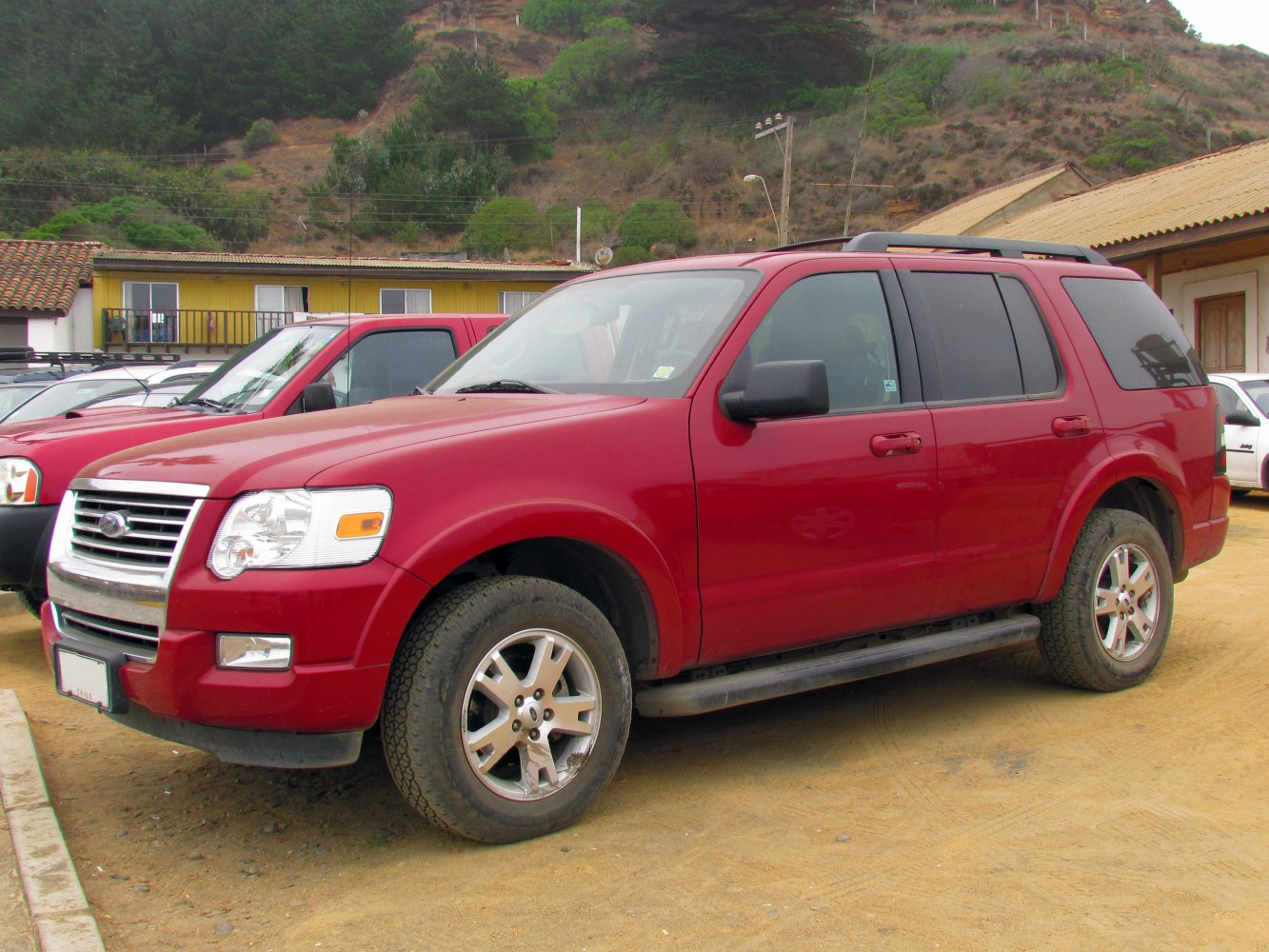 Mid-size SUV with chrome grille, roof rails, step bars