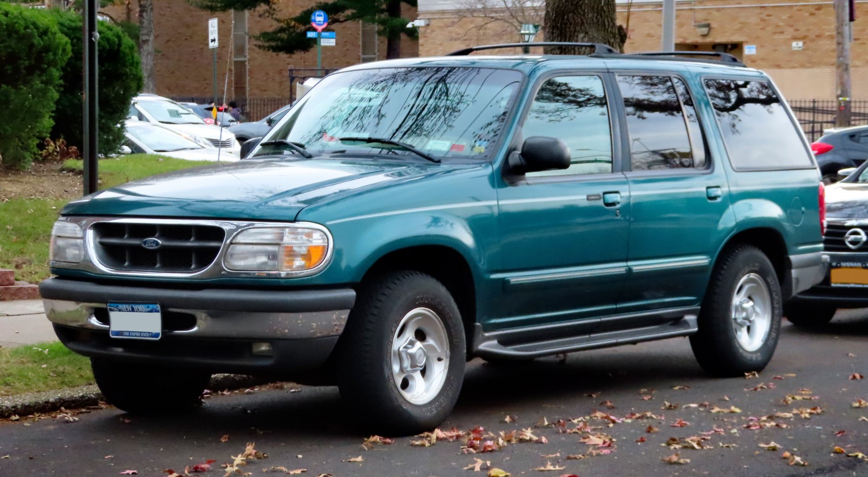 Side front SUV view with roof rack, alloy wheels, step bar, and tinted windows