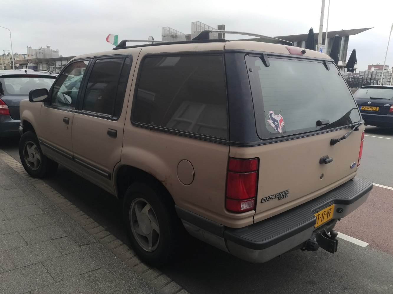 Rear-side view of vintage SUV with roof rack and rear badge