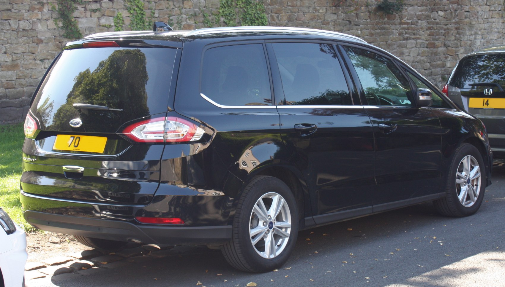 Rear and side view of black MPV with alloy wheels and updated tail lights