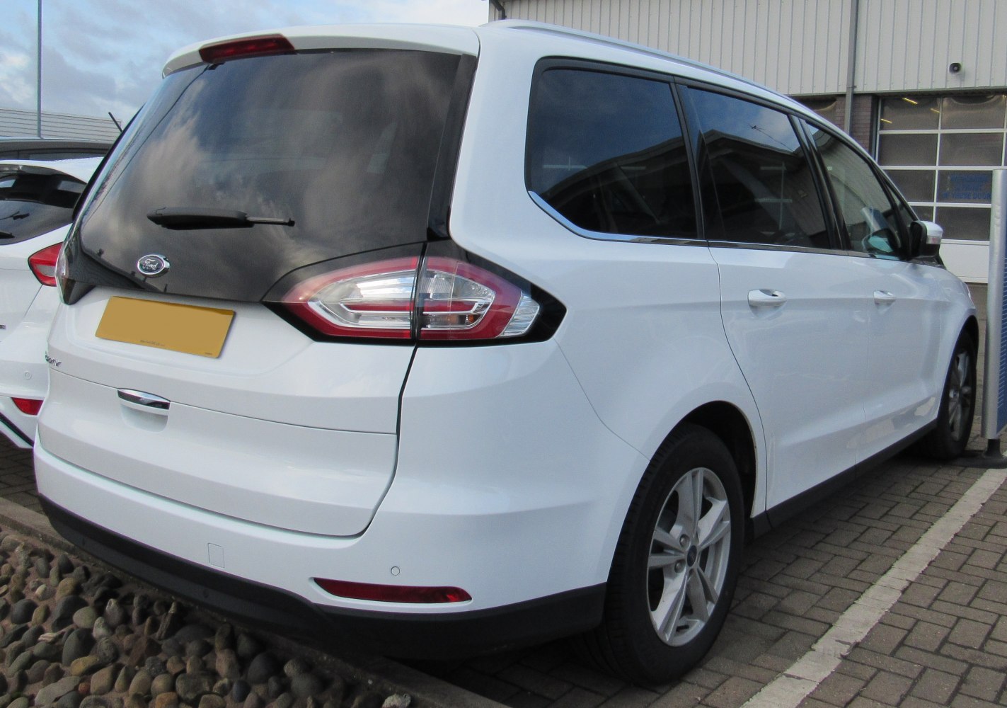 White MPV with distinctive tail lights and tinted rear windows