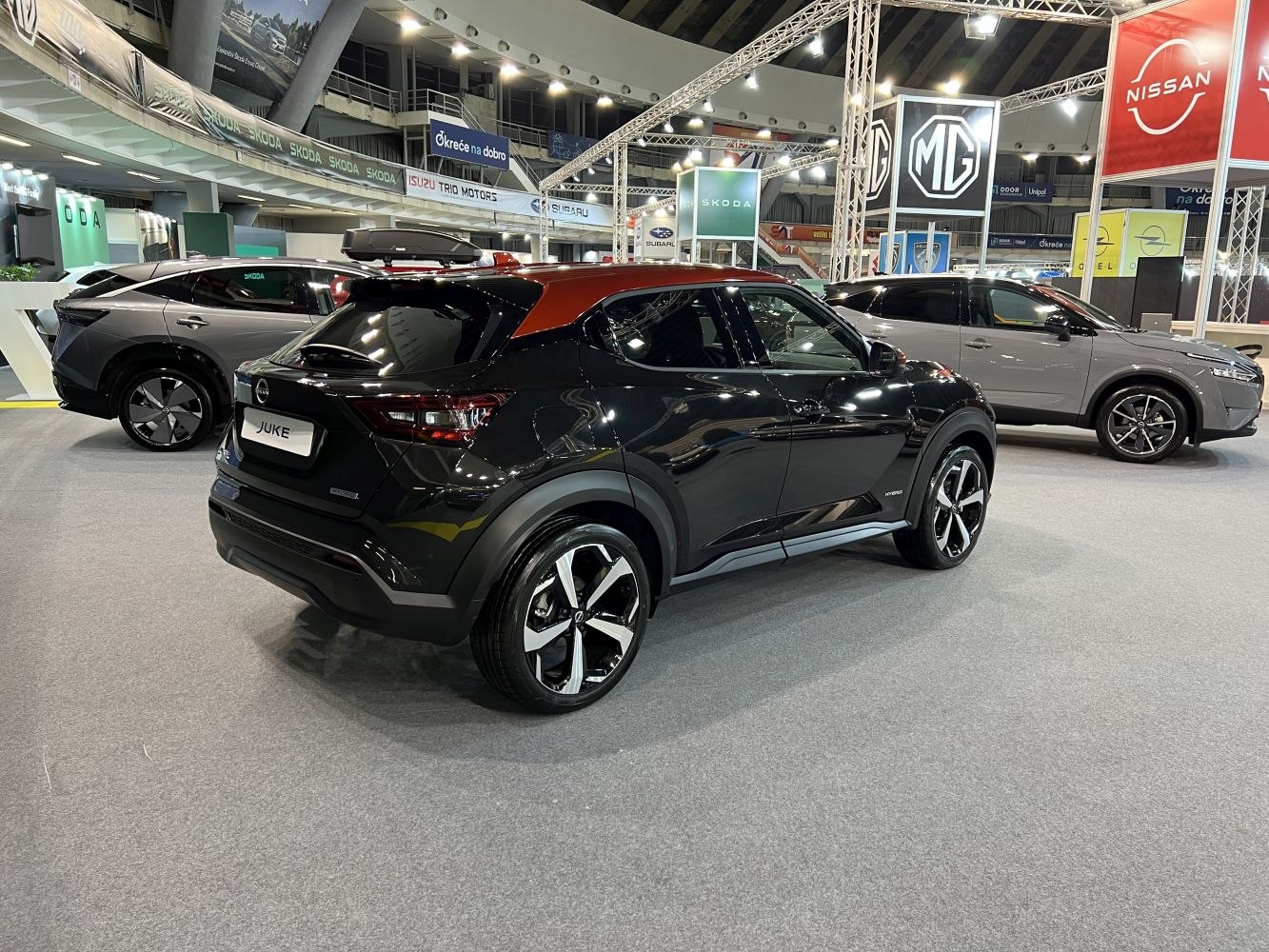 Rear side view of black SUV with orange roof and hybrid badge